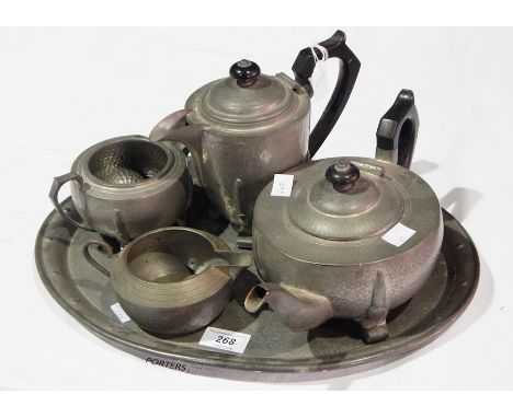 A hammered pewter tea service comprising teapot, hot water jug, cream jug, sugar bowl and tray 