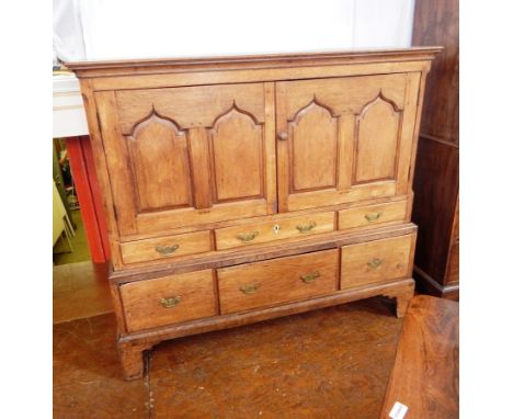 18th century oak food cupboard, with shaped fielded panel doors enclosing shelf, three short drawers and three further deep d