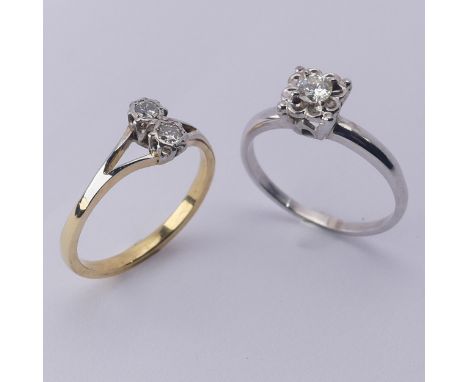 A small two stone diamond Ring, set vertically with split shoulders, mounted in unmarked yellow and white gold tested as 18ct