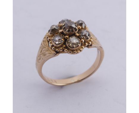 A late Victorian diamond cluster Ring,&nbsp;the old cut stones all mounted in unmarked yellow gold, with flared engraved shou