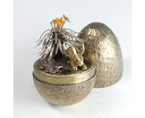 Stuart Devlin; A silver gilt 'Surprise Egg', hallmarked London 1981, the textured egg opening to reveal a rabbit amongst foli