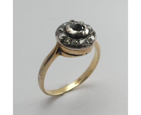 A diamond cluster Ring, the single cut stones in a circular white metal mount with an 18ct yellow gold shank, the cluster 11.
