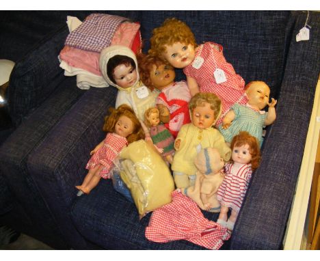 A bisque head doll together with other vintage dolls