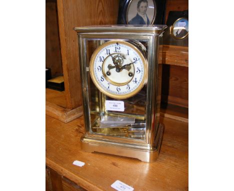 A 27cm high brass four glass mantel clock with visible escapement