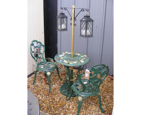 A cast iron bistro set, together with make-shift lantern