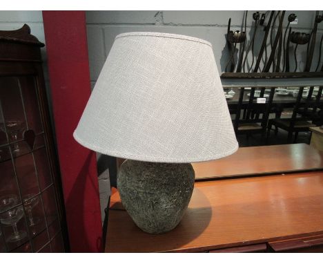 A large stoneware table lamp with shade
