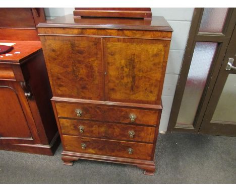 A 20th Century burr walnut veneered chest, cupboard over three drawers on bracket feet, 118cm x 81cm x 48cm
