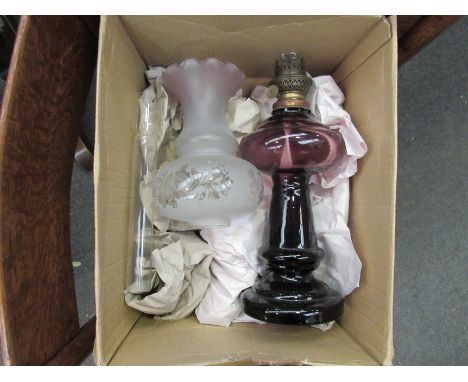 A purple glass oil lamp with frosted and frilled edge shade