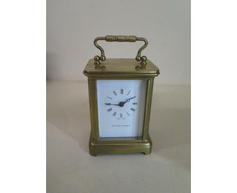 A miniature brass carriage clock by Matthew Norman, 8cm tall with handle up, in good condition with key , running . 