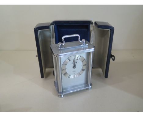 A looping carriage alarm clock, 8.5cm tall with handle up, in a blue leather travel case, in working condition 