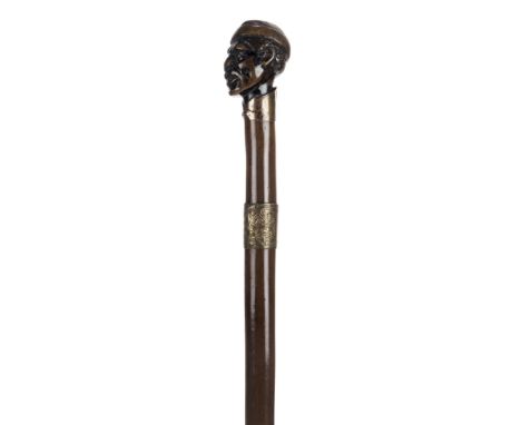 *Walking Stick. 19th century walking stick,  the knop carved as a Negro wearing a tasselled hat with copper collar fashioned 