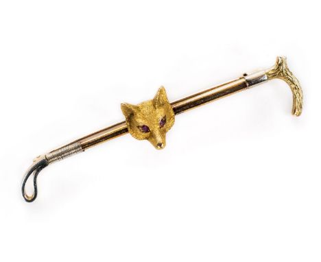 *Brooch. A yellow metal bar brooch, 1920s, with foxes head set with ruby eyes on a riding crop, makers mark A&W, 6.5g gross w