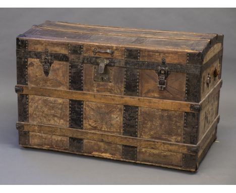*Trunk. A late 19th century travelling trunk,  the dome top with slatted struts and leather covered, enclosing cloth lining a