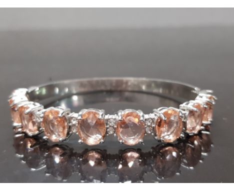 A PINK STONE AND SILVER PLATED STEEL BANGLE