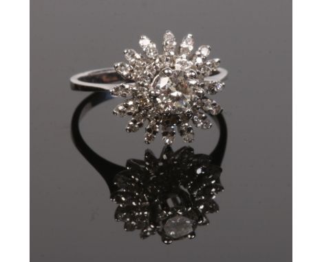 A white gold and diamond starburst cluster ring. With a claw set brilliant cut diamond approximately 0.5ct under a two tier h