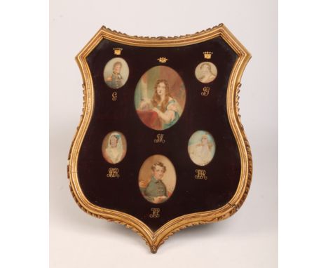 A 19th century set of six portrait miniatures framed as one in a shield shaped gilt frame, 48cm x 42cm.