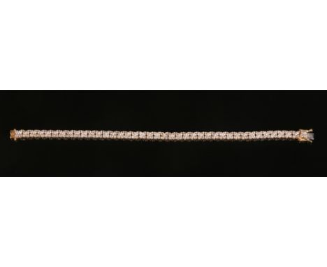 An 18 carat gold and diamond tennis bracelet. Each link set with a daisy cluster of four round cut diamonds, 19cm.Condition r