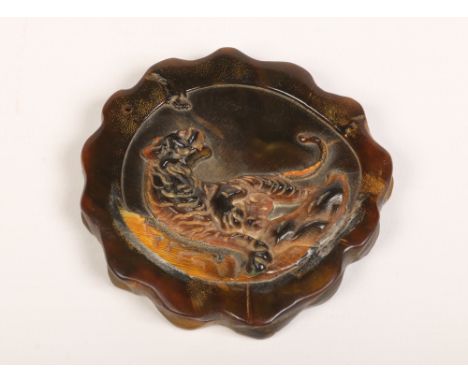 A Chinese carved horn amulet with lobed rim and decorated in relief with a tiger, 7.5cm wide.&nbsp;Condition report intended 