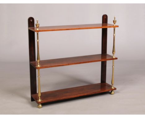 A 19th century rosewood and brass three tier wall shelf with urn shaped finials, 74cm wide, 71cm high.