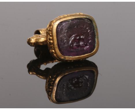 A Victorian pinchbeck and amethyst fob seal. The matrix carved with a rabbit and script, 3cm.Condition report intended as a g