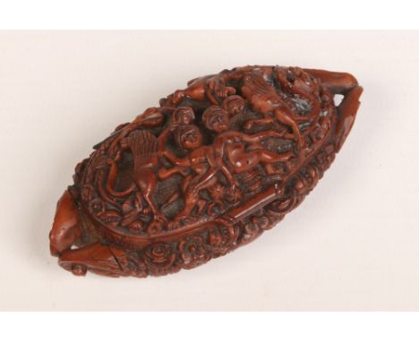 A 19th century coquilla nut snuff box with hinged cover and scrolling handles. Carved in relief with figures and animals on a