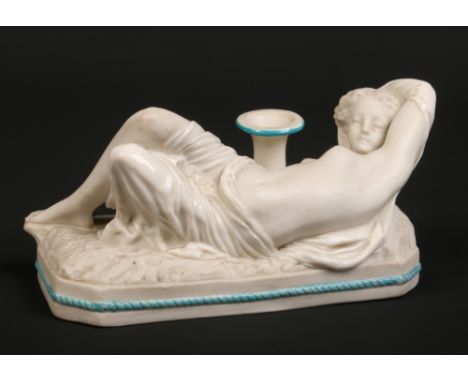 A Victorian bisque pen stand. Surmounted with the figure of a reclining semi clad maiden over a canted rectangular plinth edg