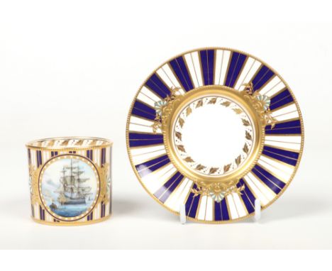 A Lynton Porcelain Company coffee can and saucer by Stefan D. Nowacki. Gilded and jeweled on a cobalt blue and gold striped g