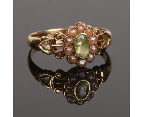 A George V 18 carat gold floriform cluster ring set with peridot and seed pearls. Assayed Chester 1911, size P 1/2.Condition 