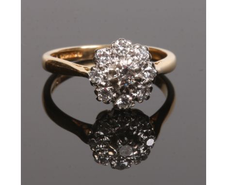 An 18 carat gold and diamond nine stone daisy cluster ring. Set with brilliant cut diamonds. Size L.Condition report intended