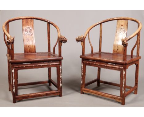 A pair of Chinese horseshoe back armchairs with carved dragon head terminals and inlaid with mother of pearl depicting traili