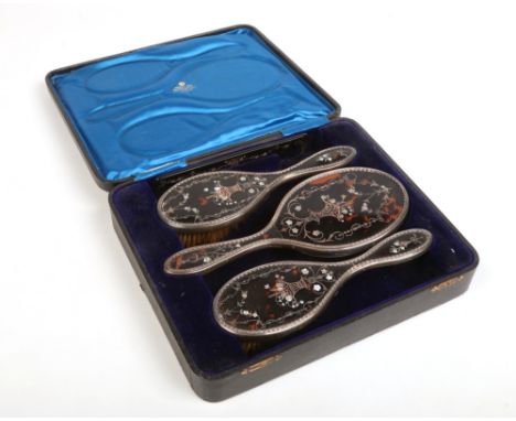 An Edwardian cased silver mounted four part brush set by William Comyns retailed by West &amp; Son, Dublin. The back of each 
