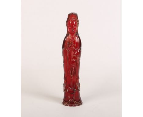 A Chinese carved cherry amber coloured statue of Guanyin. Dressed in flowing robes and clutching prayer beads, 28.25cm.Condit