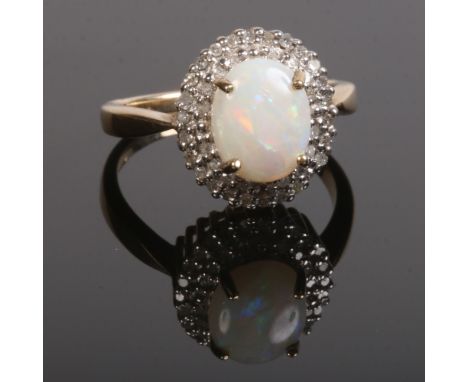 A 9 carat gold halo cluster ring. Set with a large opal under a two row border of diamonds. Size P, opal 10mm x 8mm.Condition