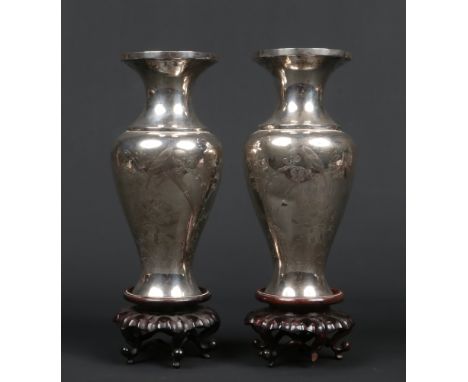 A pair of&nbsp; early 20th century Chinese baluster formed silver vases raised on hardwood plinths. Engraved with birds and s