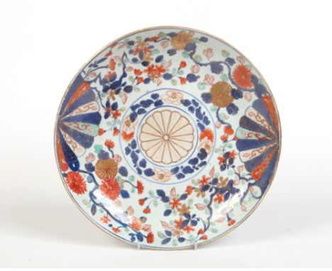 A 19th century Chinese Imari dish. Painted with a brocade pattern incorporating mons and trailing foliage. Underglaze blue co