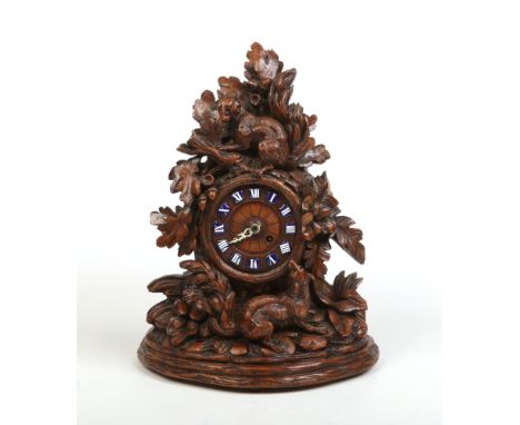 A 19th century walnut Black Forest mantel clock. The case is carved with a pair of squirrels, with acanthus leaves, acorns an