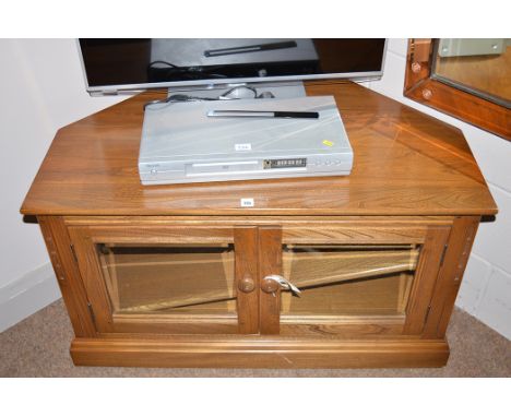 A dark stained elm Ercol television stand, with glazed panel doors enclosing a shelf, 96cms wide.