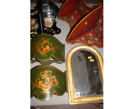 A pair of green painted wall pockets with bird and floral design; a red painted floral wall bracket; a black painted corner w