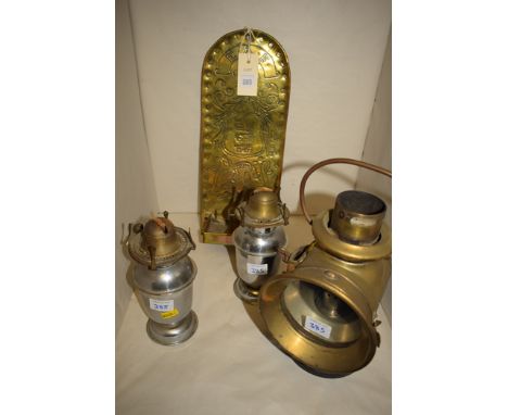An embossed brass candle bracket, decorated with Faulk family crest depicting three boars, motto 'Jure Non Dono 1900', with E