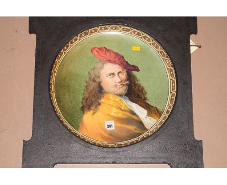 A hand-painted ceramic charger depicting a portrait of a gentleman, possibly after Rembrandt (cracked), in wooden frame.