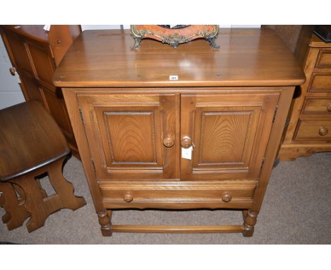 An Ercol dark stained elm side cabinet, fitted two doors and a single drawer, 78cms wide.