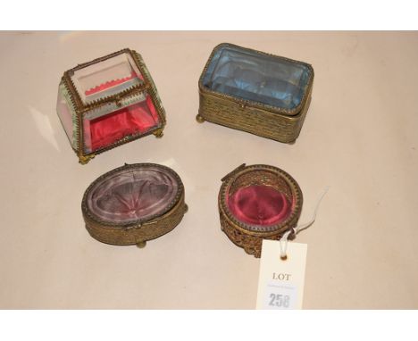 Four late 19th Century gilt metal and bevelled glass ring boxes.