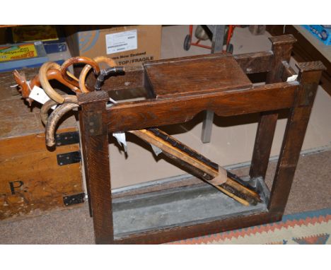 An early 20th Century oak stick and umbrella stand with lead liner; and a small quantity of walking sticks various.