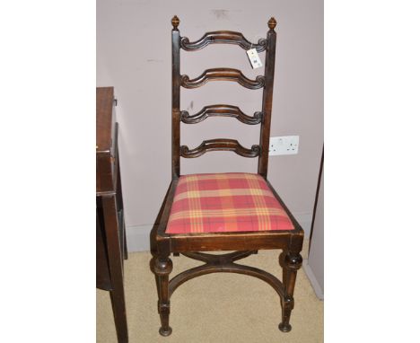 A set of four stained mahogany ladder-back dining chairs, the drop-in seats upholstered in checked material, the legs joined 