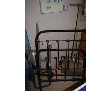 An early 20th Century black painted metal single bed; an early 20th Century grass roller; and an early 20th Century wooden sa