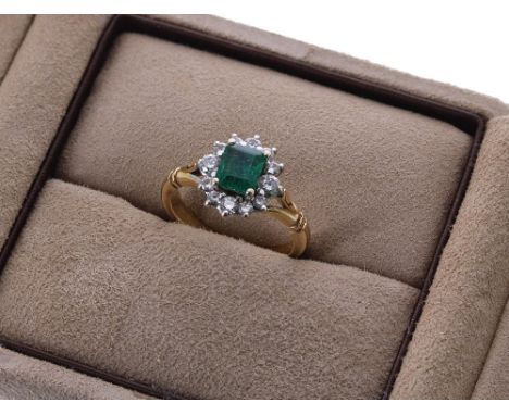 18ct emerald and diamond cluster ring, the emerald 0.66ct approx, in a setting of twelve diamonds, cluster 11mm x 10mm, 3.4gm