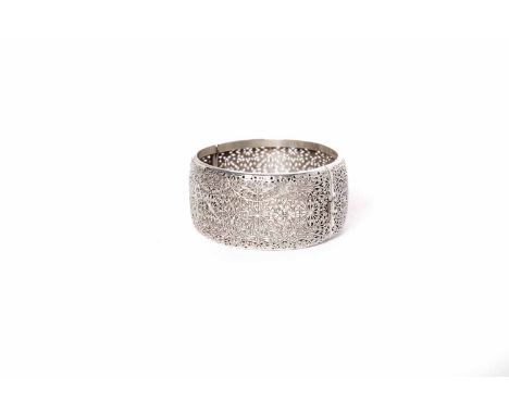 EARLY 20TH CENTURY INDIAN SILVER FILIGREE BANGLE with pierced scrolling design, 30g