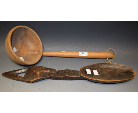 A carved softwood ladle; a carved hardwood tribal wall spoon, 48cm