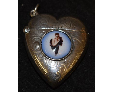 A sterling silver love heart shaped vesta case, applied with circular enamel panel printed with an Edwardian beauty