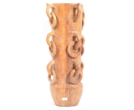 A vintage 20th century hand carved wooden vase. The vase having a tapered cylindrical body, bulbous base with multiple carved